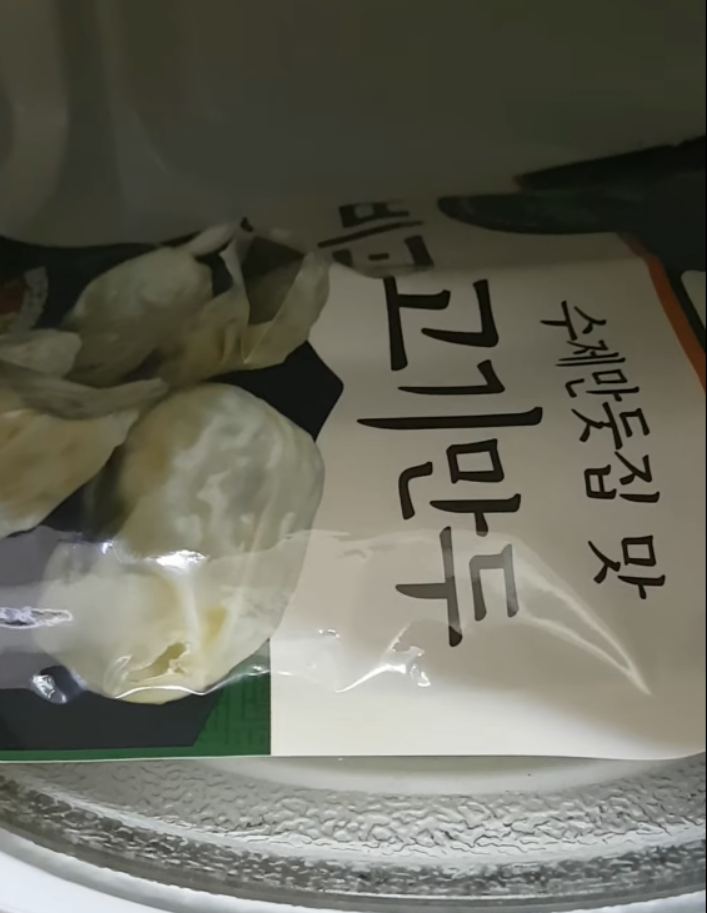 전자레인지 안에 넣어진 냉동만두 봉지