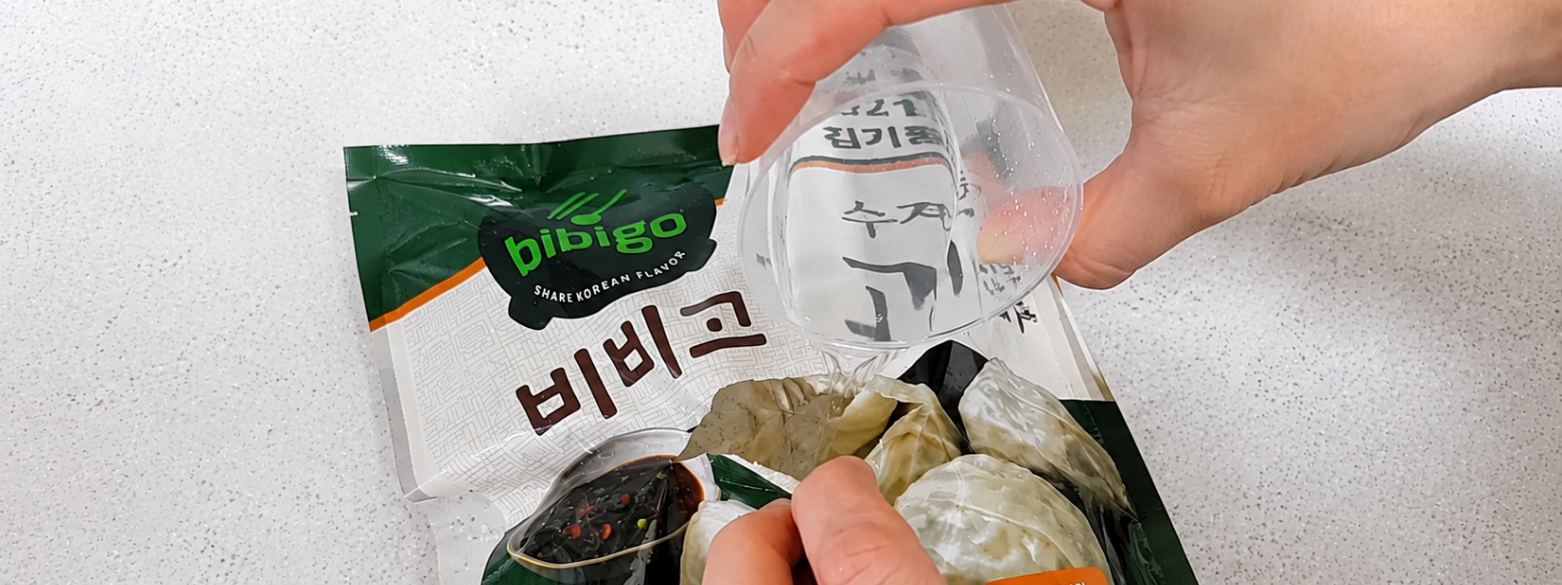 종이컵으로 봉지 안에 물을 붓는 모습